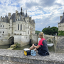 Radfahrerin blickt auf Schloss Chenonceau an der Loire in Frankreich.