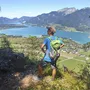 Person beim Wandern mit Blick auf den Wolfgangsee und die umliegenden Berge.