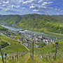 Blick auf Moseltal mit Weinbergen und Fluss, umliegende Hügel im Hintergrund.