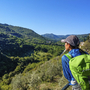 Wanderer genießt den Ausblick über grüne Hügel und Täler in Umbrien.