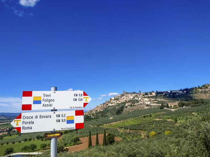 Wegweiser mit Landschaftspanorama in Umbrien, Italien.
