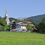 Außenansicht des Kirchenwirts Grosau mit umliegender Landschaft.