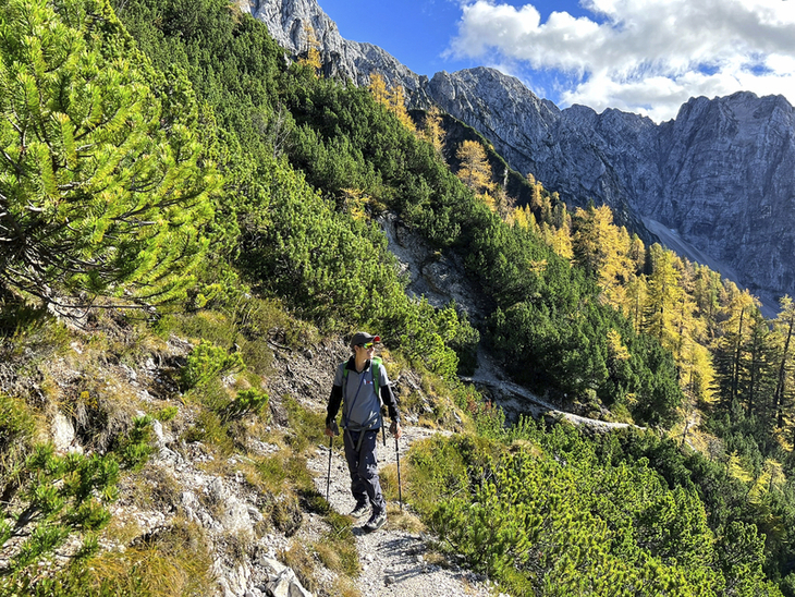 Eine Frau wandert auf einem Bergpfad in den julischen Alpen.