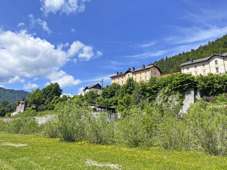 Historische Gebäude auf einem Hügel im Friaul, umgeben von grüner Landschaft.