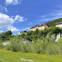 Historische Gebäude auf einem Hügel im Friaul, umgeben von grüner Landschaft.