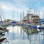 Boote liegen im Hafen von Triest vor einem Gebäude.