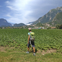 Wanderer mit Rucksack auf einem Feld vor den Julischen Alpen in Friaul.