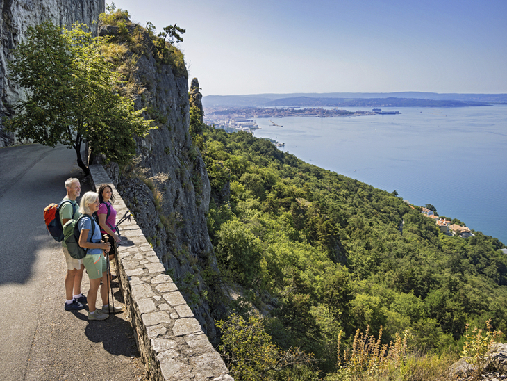 Wanderer genießen den Blick auf die Küstenlandschaft und das Meer in Friaul, Italien.