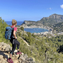 Wanderin genießt den Ausblick auf Port de Sóller, Meer und Berge auf Mallorca.