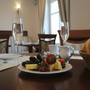 Ein Frühstückstisch mit Brötchen, Obst und Getränken in einem Hotelrestaurant.