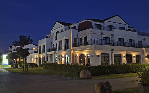 Hotelgebäude bei Nacht mit Beleuchtung und Gartenanlagen.