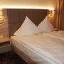 Doppelbett in einem Hotelzimmer mit moderner Beleuchtung.
