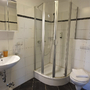 Modernes Badezimmer mit Dusche, Waschbecken und Toilette.