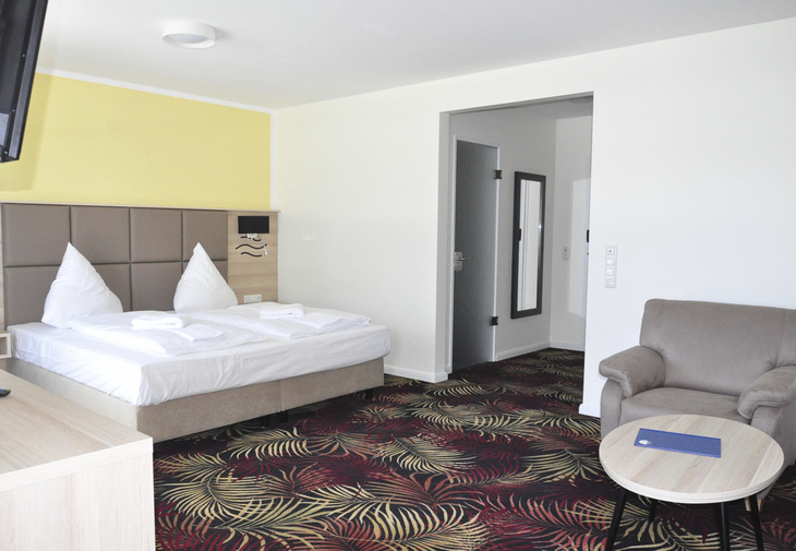 Doppelzimmer im Bellevue Hotel mit modernem Interieur und buntem Teppich.