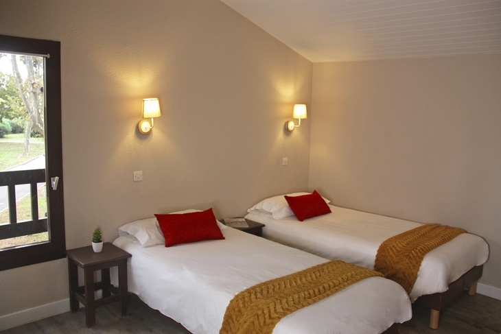 Zwei Betten mit Kissen und Decken in einem Hotelzimmer.