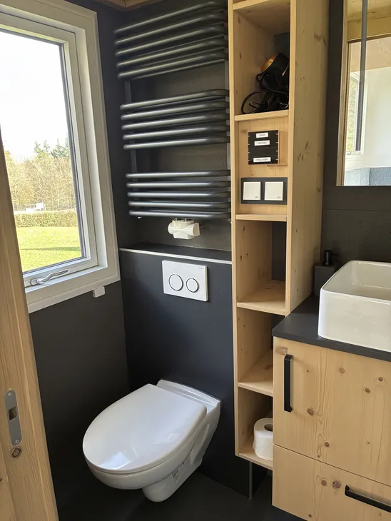 Badezimmer eines Tiny Houses mit Toilette und Waschbecken.