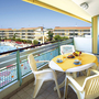 Balkon mit Tisch und Stühlen, Blick auf Pool und Gebäude im Villaggio Planetarium Resort.