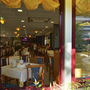Blick in ein Restaurant mit gedeckten Tischen und gelber Dekoration.