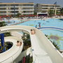 Poollandschaft mit Wasserrutsche und Gebäuden im Villaggio Planetarium Resort in Bibione.