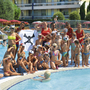 Kindergruppe und Betreuer posieren am Rand eines Schwimmbeckens im Resort.