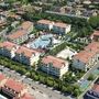 Luftbild des Villaggio Planetarium Resort in Bibione, umgeben von Gebäuden und Grünflächen.