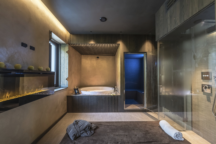 Luxuriöser Spa-Bereich mit Whirlpool, Handtuch, Deko-Elementen und stimmungsvoller Beleuchtung.