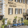 Fassade des Hotel Garden mit Pflanzen und Sitzgelegenheiten im Freien.