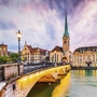 Brücke und historische Gebäude in Zürichs Altstadt bei Sonnenuntergang.