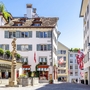 Straße in der Altstadt von Zürich mit historischen Gebäuden und Schweizer Fahnen.