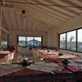Blick in ein festlich gedecktes Restaurant mit großen Fenstern und Ausblick auf den Campingplatz.