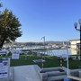 Blick auf einen Campingplatz mit Liegestühlen und Blick auf einen Hafen.