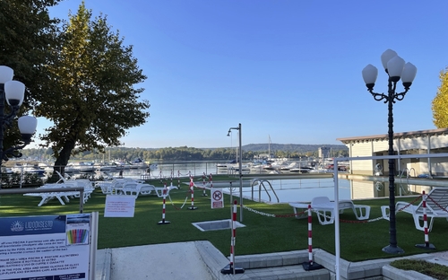 Blick auf einen Campingplatz mit Liegestühlen und Blick auf einen Hafen.