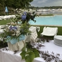 Gedeckter Tisch mit Blumenarrangement neben Pool, im Hintergrund Yachthafen.