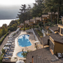 Panoramablick auf eine Hotelanlage mit Pool und umliegenden Bäumen am Hang.