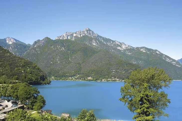Blick auf den Ledrosee mit umliegenden Bergen und klarem Himmel.