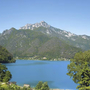 Blick auf den Ledrosee mit umliegenden Bergen und klarem Himmel.