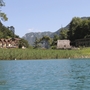 Uferansicht mit Häusern, Bäumen und Bergen am Ledro-See.