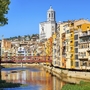 Bunte Häuser und Fluss in Girona, Katalonien mit Brücke und Kirche im Hintergrund.