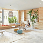 Moderne Hotel-Lobby mit Pflanzen, Sitzgelegenheiten und einer sitzenden Person.
