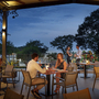 Gäste im Restaurant auf einer Terrasse am Abend unter freiem Himmel.