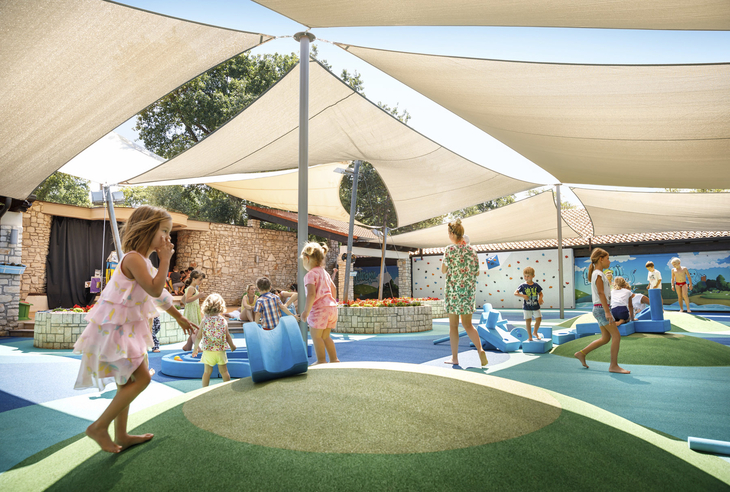 Kinder spielen auf einem überdachten Spielplatz im Freien.