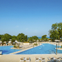Poolbereich des Camping Maravea Resorts mit Liegestühlen und Bäumen im Hintergrund.