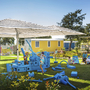 Spielplatz mit Kindern in einem Ferienresort, umgeben von kleinen Ferienhäusern.