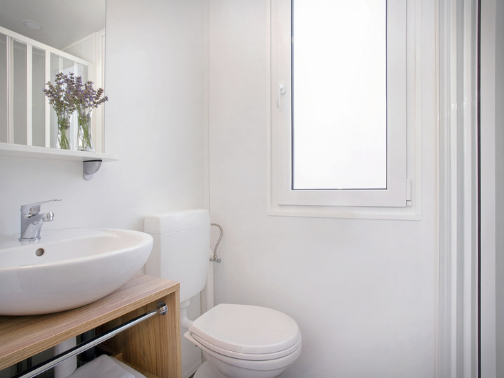 Modernes Badezimmer mit Waschbecken, Toilette und Fenster.