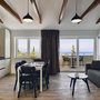 Wohnzimmer mit Sofa, Esstisch, Küche und Balkon mit Meerblick.