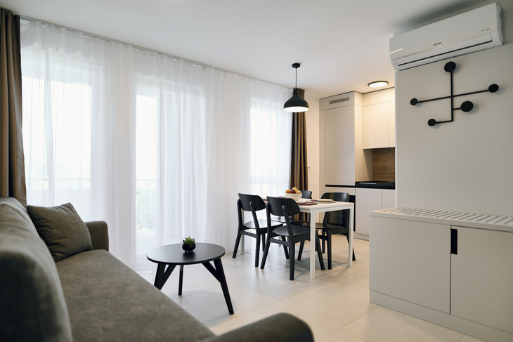 Wohnzimmer mit Sofa, Esstisch, Stühlen und Küche, modernes Design.
