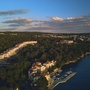 Küstenansicht von Malinska auf der Insel Krk mit Gebäuden und dichtem Wald am Meer.