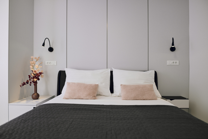 Modernes Schlafzimmer mit Doppelbett, Nachttischen und dekorativer Beleuchtung.