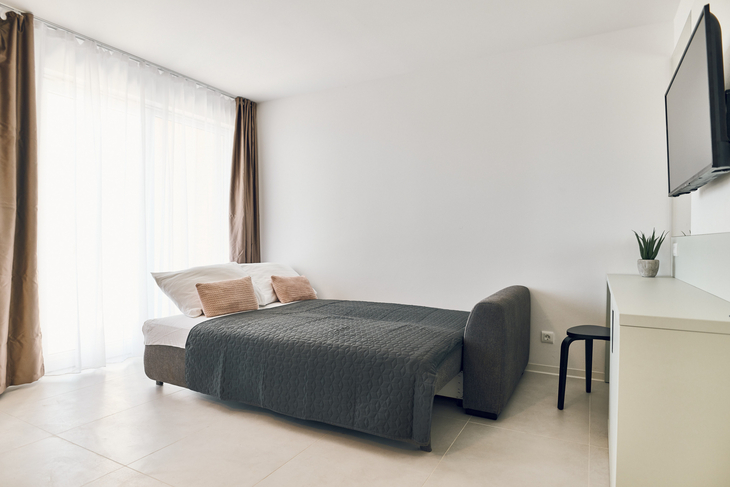 Modernes Wohnzimmer mit offener Küche, hell und stilvoll eingerichtet.