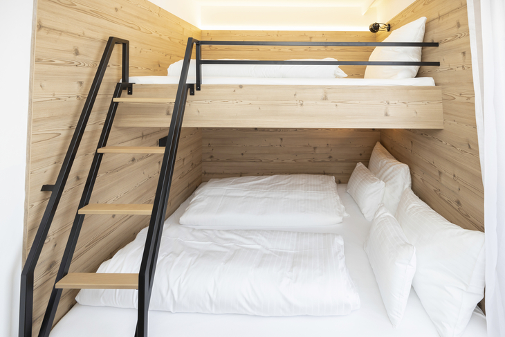 Modernes Etagenbett in einem hellen, holzverkleideten Raum.